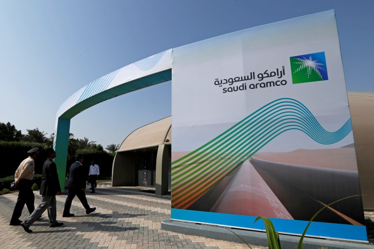 The logo of Aramco is seen as security personnel walk before the start of a press conference