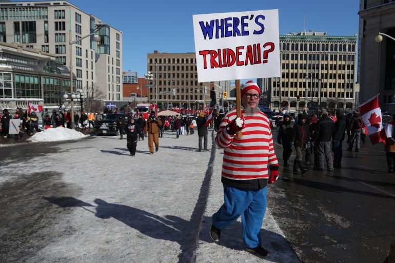 A protester carries a sign during the Freedom Convoy demonstration in Ottawa