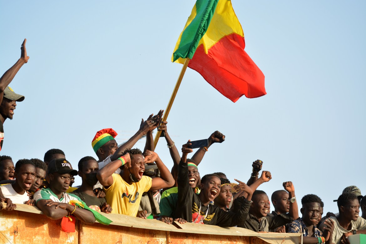 Senegalese soccer fans wait to welcome back their team in front of the military airport in Dakar