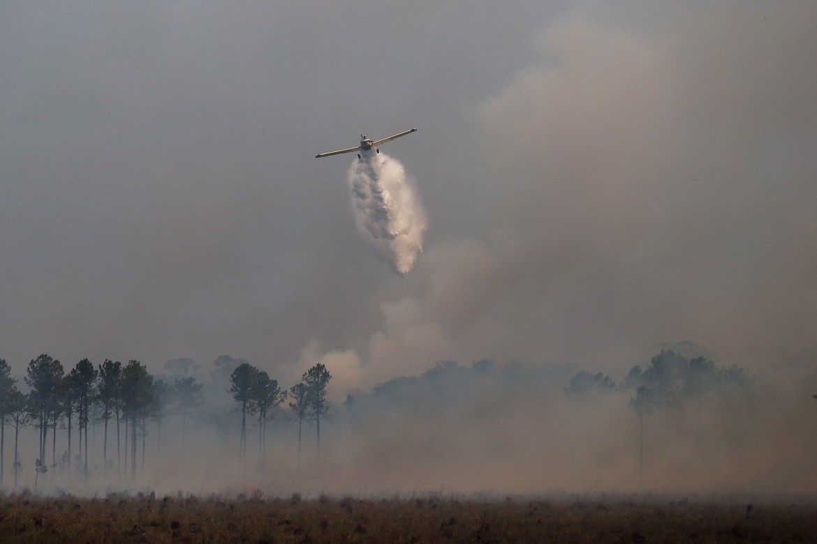 An aircraft sprays water on the burned fields in the town of Santo Tome