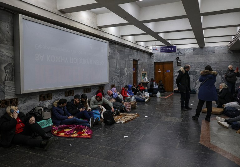 La gente se sienta en el piso de una estación de metro en Kharkiv 