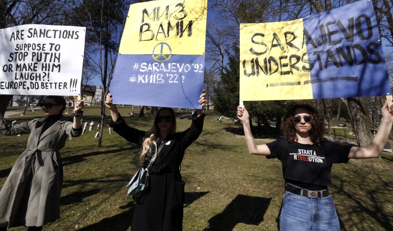 Las mujeres bosnias llevan carteles mientras asisten a una protesta contra el ataque de Rusia a Ucrania en Sarajevo, Bosnia y Herzegovina.