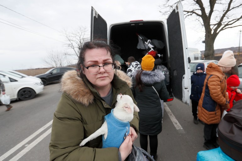 A Ukrainian refugee woman holds her pet