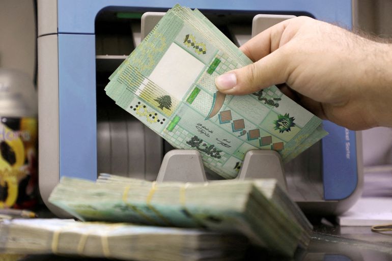 A man counts Lebanese pound banknotes