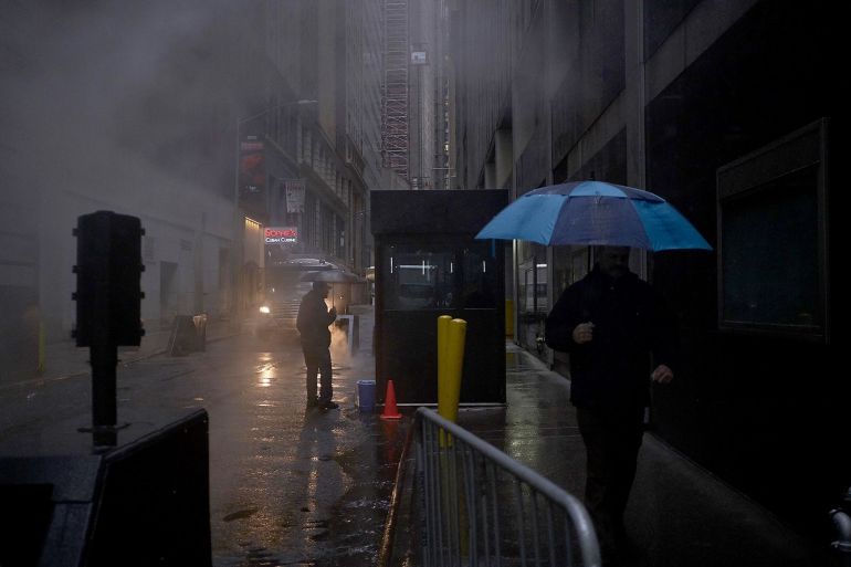 A pedestrian carries an umbrella while walking along Exchange Place in New Yor