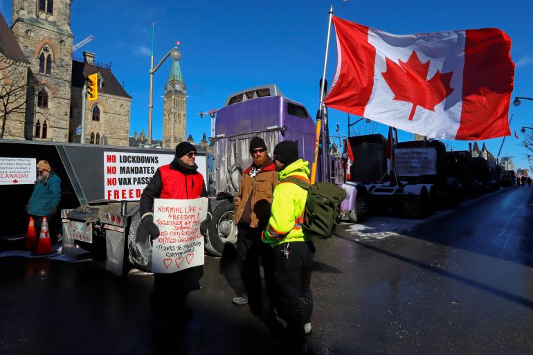 People stand in front of Parliament Hill as truckers and their supporters continue to protest against coronavirus disease (COVID-19) vaccine mandates in Ottawa, Ontario, Canada