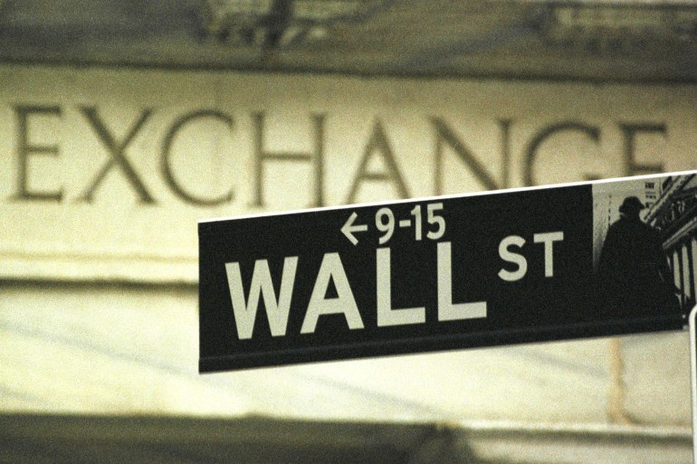A Wall Street street sign stands in front of the New York Stock Exchange in New York,