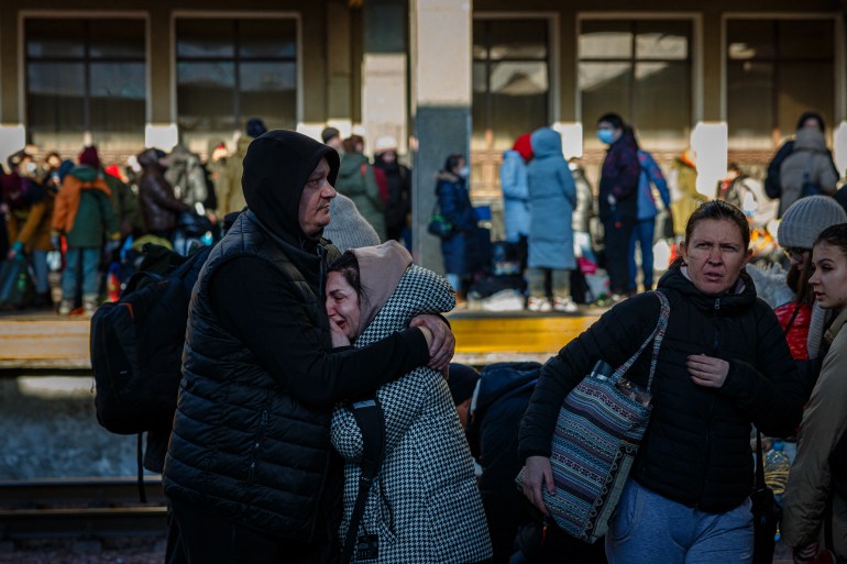 A man hugs his wife before she boards an evacuation train at Kyiv central train station