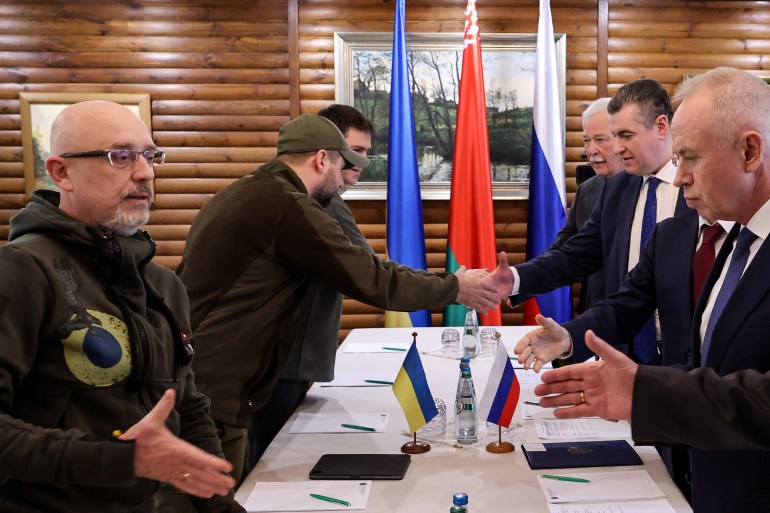 Ukrainian Defence minister Oleksii Reznikov shakes hands with Russian negotiators prior to talks between delegations from Ukraine and Russia in Belarus' Brest region on March 3, 2022,