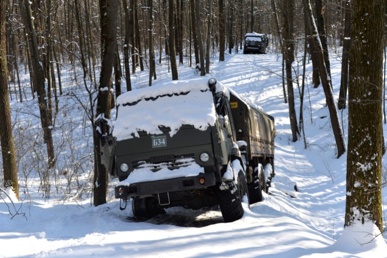 A column of Russian military vehicles is seen abandoned in the snow, in a forest not far from Kharkiv