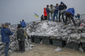 Citizens fill bags with sand for frontlines, along the beach of the Black Sea city of Odesa, in the southern Ukraine [Bulent Kilic/AFP]