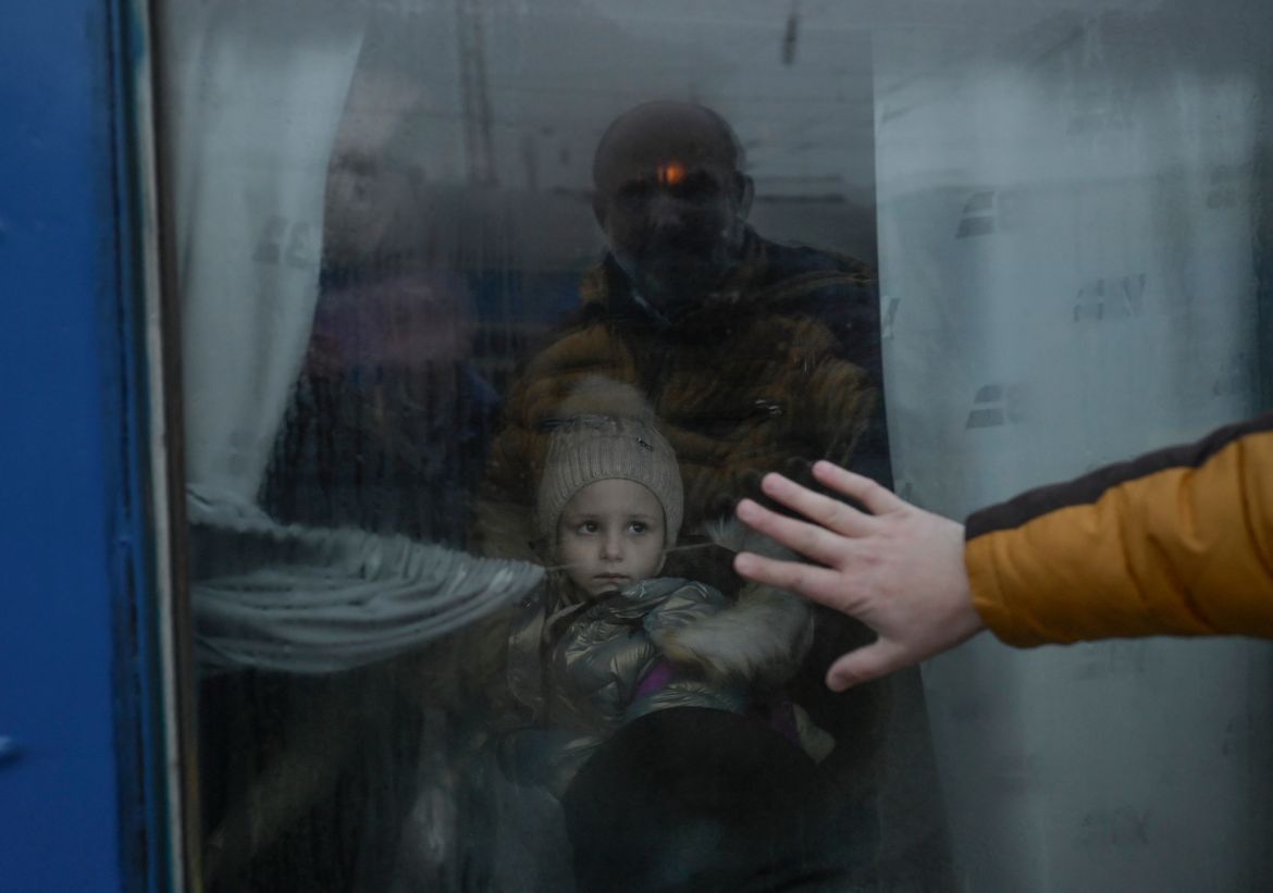 A father puts his hand on the window as he says goodbye to his daughter in front of an evacuation train at the central train station in Odessa