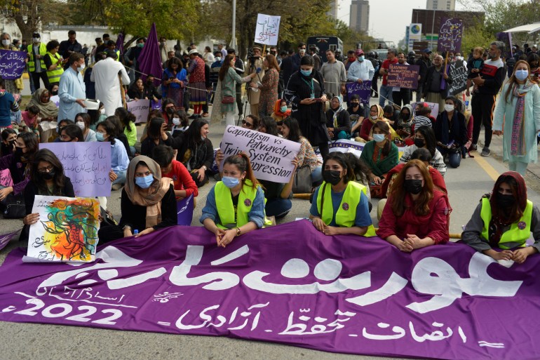 Women protest and carry banners.