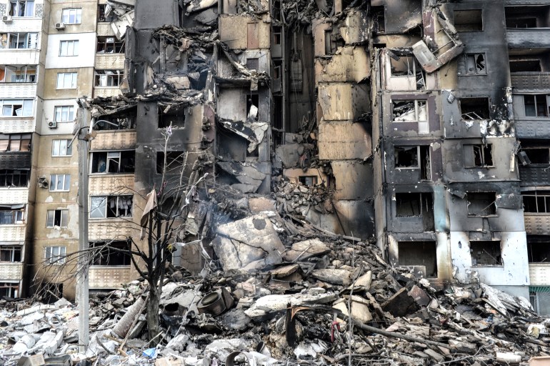 This picture shows an apartment building destroyed after shelling the day before in Ukraine's second-biggest city of Kharkiv on March 8, 2022. - The number of people fleeing the war flooding across Ukraine's borders to escape towns devastated by shelling and air strikes passed two million, in Europe's fastest-growing refugee crisis since World War II, according to the United Nations. 