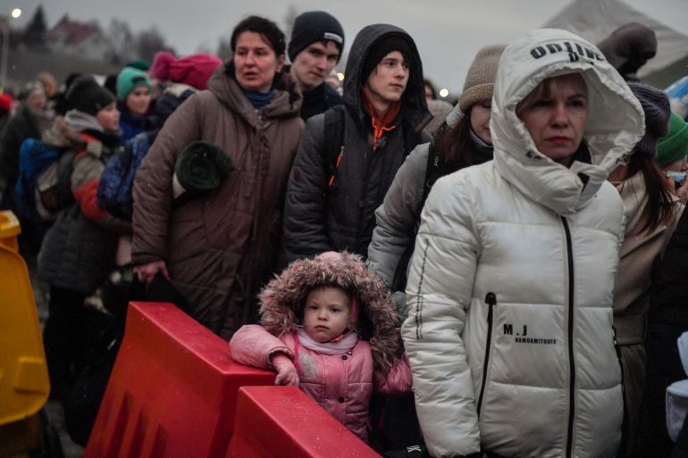 Ukrainian refugees wait for their transportation after crossing the border into Poland at the border crossing in Medyka, southeastern Poland.