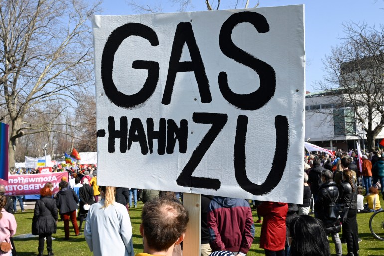 A man participating in a demonstration against the war in Ukraine holds up a banner reading "Close Gas-tap" in Stuttgart, southern Germany, on March 13, 2022.