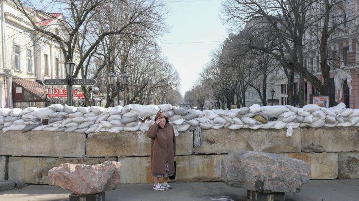 A resident stands next to a sandbag barricade in Odesa