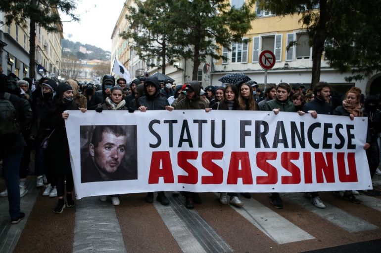 Demonstrators hold a banner as they take part in a protest on Corsica