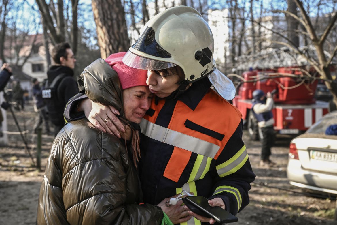 An evacuated resident is comforted by a rescue staff