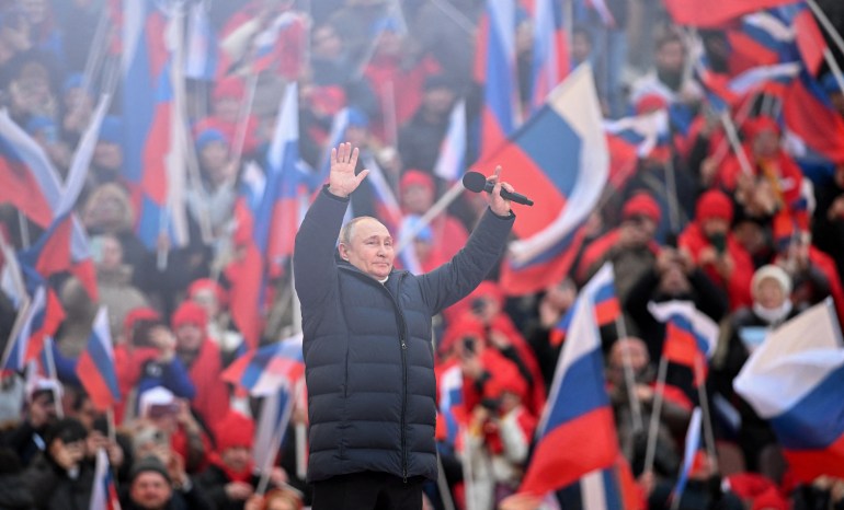 El presidente ruso Vladimir Putin saluda a la audiencia.