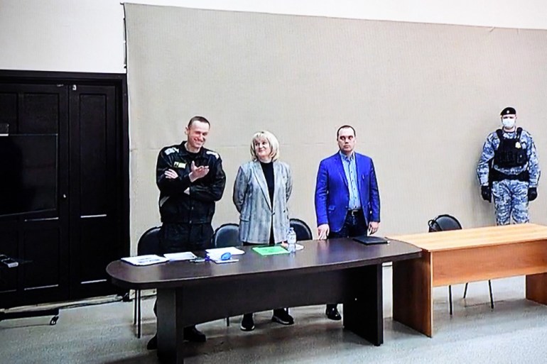 Navalny is seen on a screen via a video link during the verdict