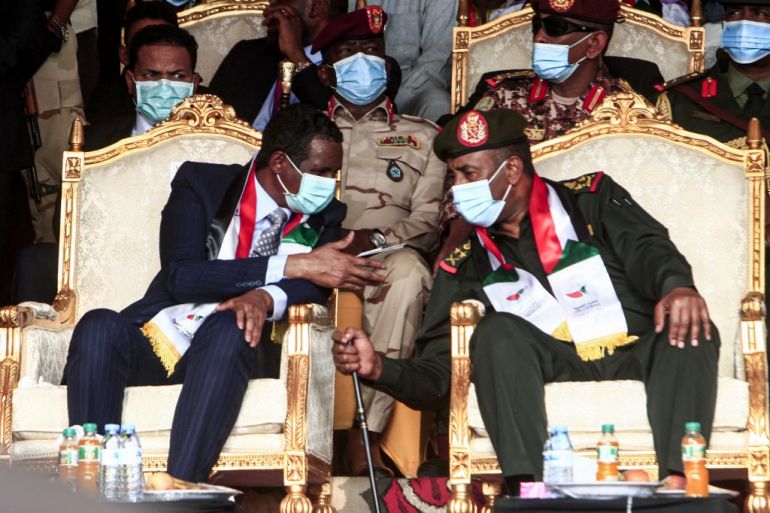 (L to R front row) General Mohamed Hamdan Daglo "Hemeti", deputy chairman of Sudan's Sovereignty Council, speaks with council chief General Abdel Fattah al-Burhan during a reception ceremony in the capital Khartoum on October 8, 2020