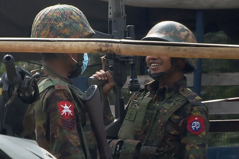 A soldier (R) carries a sniper rifle during a demonstration against the military coup where security forces fired on protesters in Mandalay on February 20, 2021.
