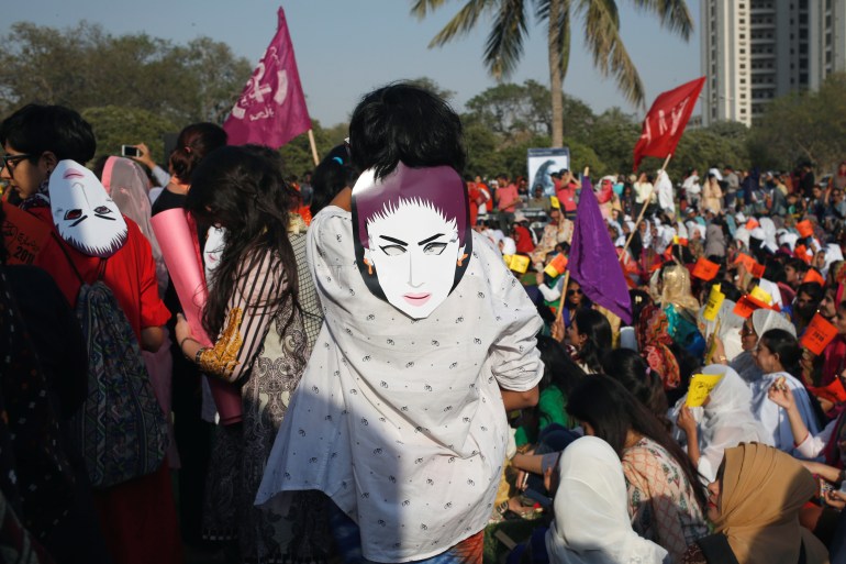 People wear masks depicting Qandeel Baloch