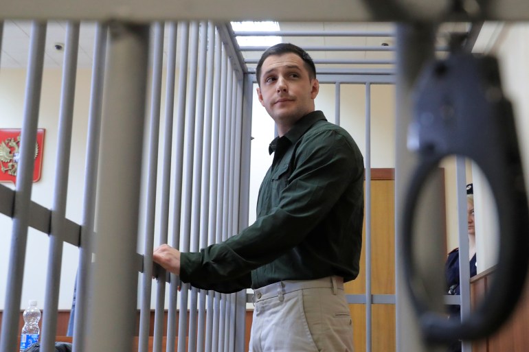 US ex-Marine Trevor Reed, who was arrested in 2019 and accused of assaulting police officers, stands inside a defendants' cage during a court hearing in Moscow