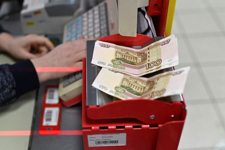 Russian 100-rouble banknotes are placed on a cashier's desk at a supermarket in the Siberian town of Tara in the Omsk region, Russia, December 14, 2021. Picture taken December