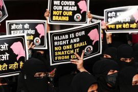 Indian women hold placards during a protest, against the recent hijab ban.
