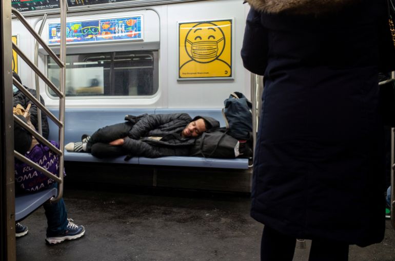 A homeless person sleeping on the train