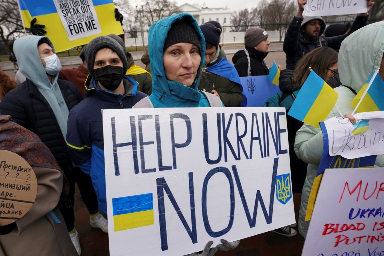 A woman holds a sign that reads 'Help Ukraine now' at a rally outside the White House