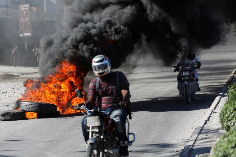 Motorcycle driving past burning tire