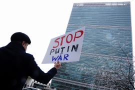 A man holds a sign in New York that reads, 'Stop Putin War'