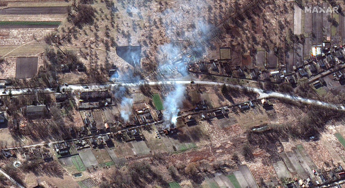 A satellite image shows part of a military convoy and burning homes, near Invankiv, Ukraine