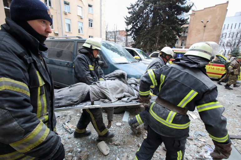 Emergency service workers are seen carrying a victims body on a stretcher in Kharkiv