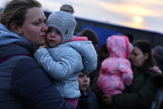 Ukrainian women who were fleeing Russian invasion of Ukraine hold their children as they arrive at a temporary camp in Przemysl, Poland, March 1, 2022.