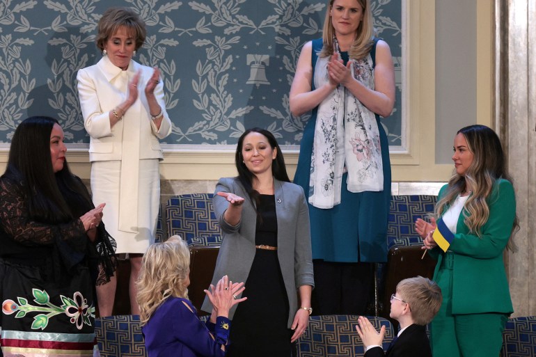 Danielle Robinson, whose husband died of a rare lung problem from exposure to burn pits, welcomes the applause after being recognized by President Joe Biden during his State of the Union address to a joint session of Congress.
