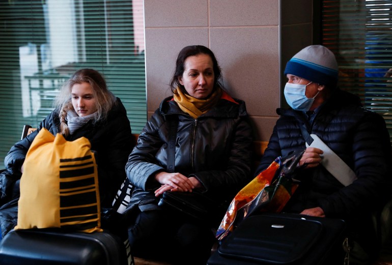 People fleeing Russia's invasion of Ukraine rest at the train station in Zahony