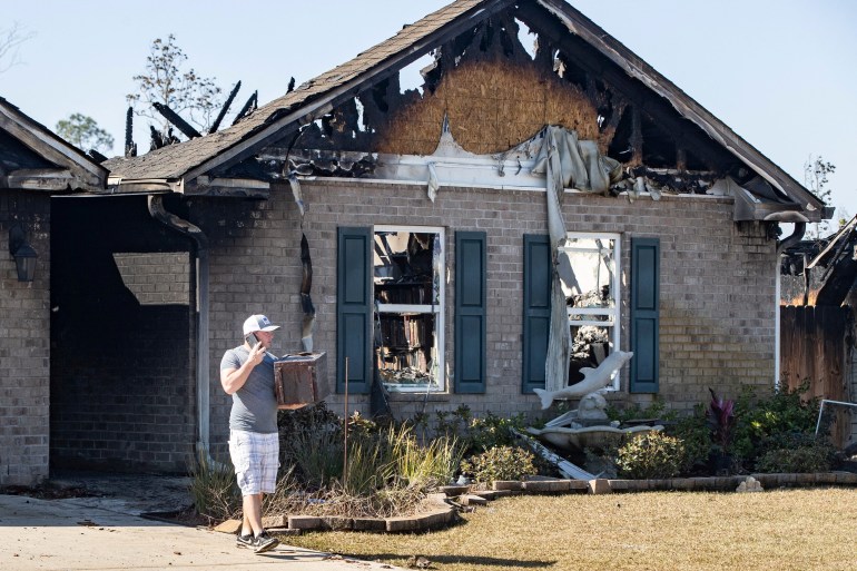 Person standing in front of scorched home