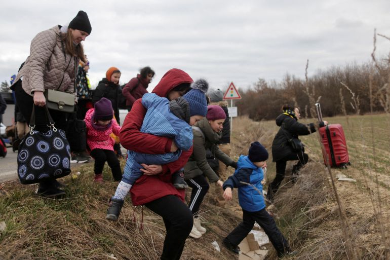 People fleeing the Russian invasion of Ukraine walk towards their transport helicopter after arriving in Slovakia