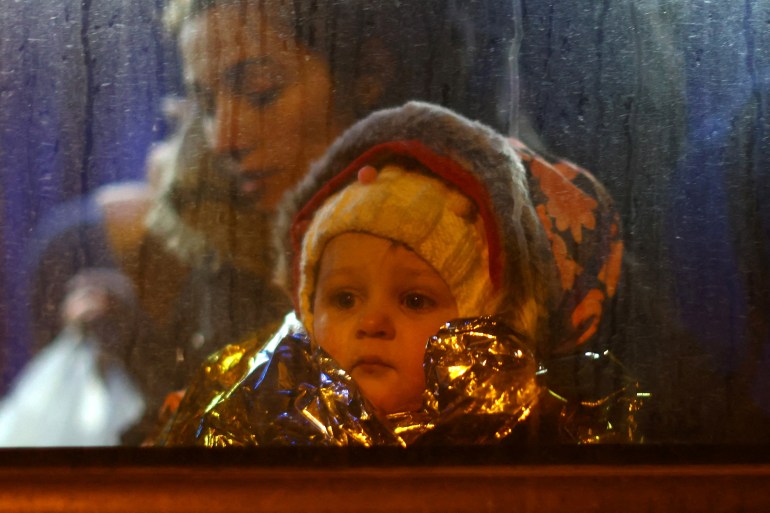 A child looks out of a window of a bus after crossing the border from Ukraine to Poland with people fleeing the Russian invasion of Ukraine, at the border checkpoint in Medyka, Poland, March 7, 2022.