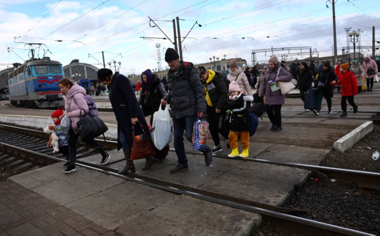 People are seen fleeing Russia's invasion at a train station in Lviv