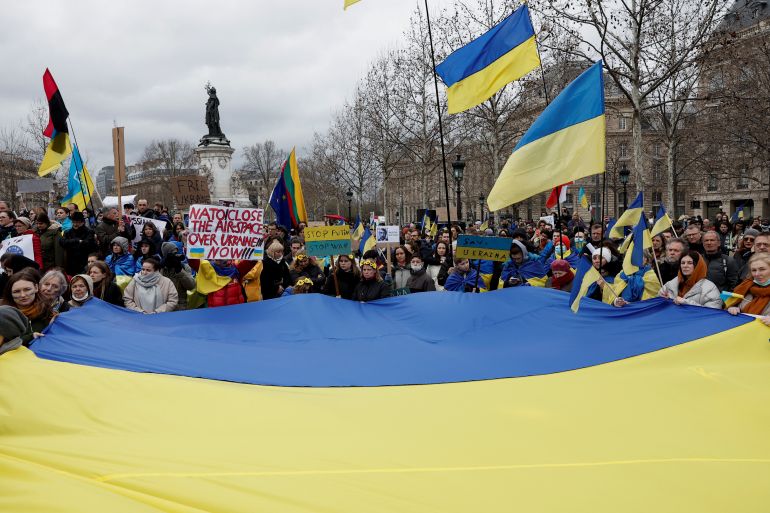 Demonstrators hold a giant Ukrainian flag as they gather on the Place de la Republique square to protest against the Russian invasion of Ukraine, in Paris, 