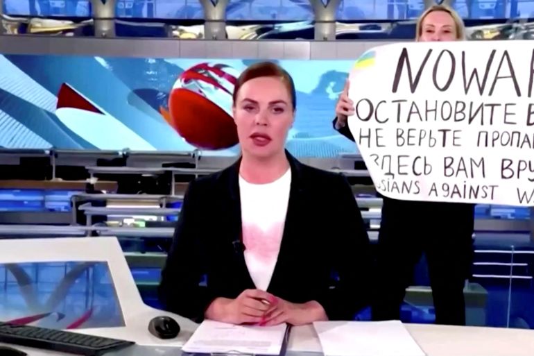 A person interrupts a live news bulletin on Russia's state TV "Channel One" holding up a sign that reads "NO WAR. Stop the war.