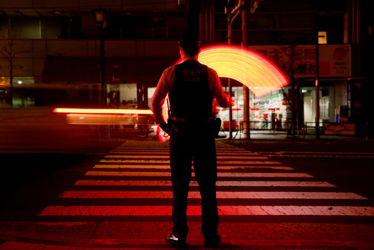A police officer directs traffic after an earthquake cut off power supplies to Tokyo 