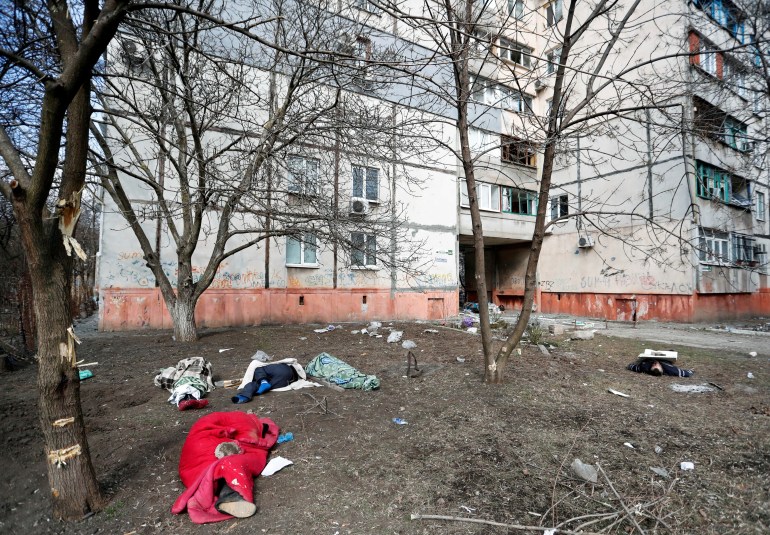 Bodies of people killed during Ukraine-Russia conflict lie on the ground next to a residential building in the besieged southern port city of Mariupol, Ukraine March 18, 2022. 