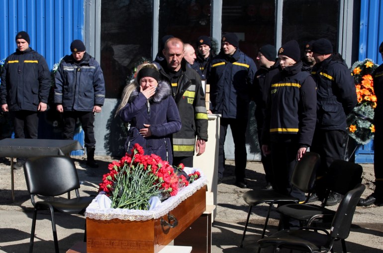 La esposa del bombero fallecido Oleksandr Podilsky reacciona durante su ceremonia de despedida
