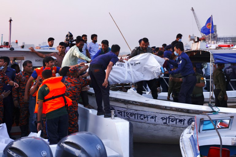 Rescue workers recover dead bodies from a sunken ferry